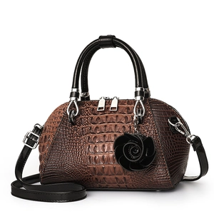 Brown crocodile embossed shell handbag with black handles and rose pendant charm