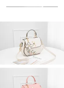 Detail of embroidered floral bucket bags with pearl metal clasp and flower charms