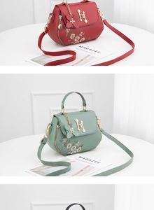 Detail of floral embroidery and H-shaped metal buckle on red and green leather handbags