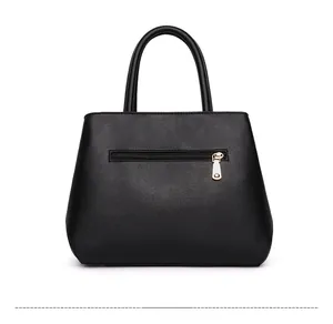 Rear view of black lychee grain leather handbag featuring a functional gold zipper pocket