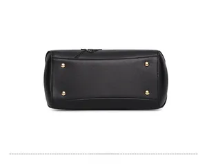 Detail view of the black pebbled leather handbag back showing golden metal feet