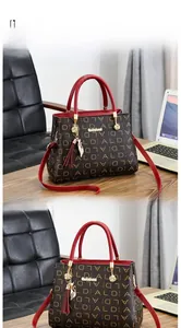 Vue latérale du sac café foncé avec lanières en cuir rouge dans un décor de bureau