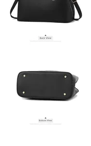 Detail view of black litchi grain leather bag back and base with gold metal feet