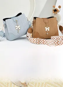 Detail of woven bucket bag with leather patchwork and ethnic geometric wide strap