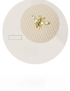Macro view of a detailed golden bee hardware ornament on a beige textured handbag