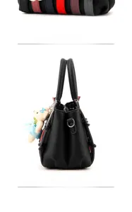 Side view of black lychee leather handbag featuring colorful side trim and bear charm