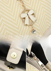 Detail of beige woven bucket bag featuring gold butterfly charm and magnetic closure