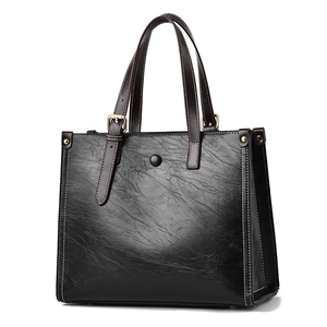 Classic black oil-wax leather tote bag with white contrast stitching and gold hardware