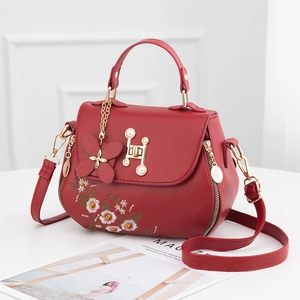 Elegant red embroidered bucket bag for women with floral patterns and a pearl gold clasp