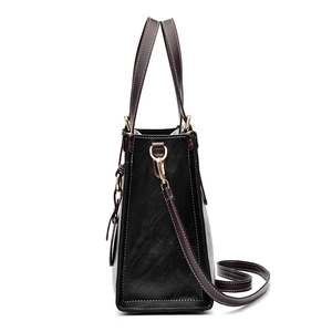 Classic two-tone tote bag in black and brown leather with golden hardware accents