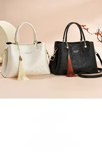 Détail de grands sacs cabas avec gaufrage floral rétro et glands décoratifs en deux couleurs