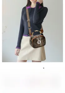 Close-up of brown crocodile pattern leather bag with bamboo handle and jacquard strap