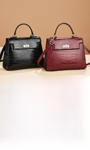 Detail of crocodile embossed texture and golden metal rotary lock on elegant handbags