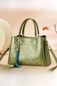 Détail du sac vert gaufré floral avec pompon et logo doré Fashion & Classic