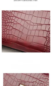 Detail of reddish brown crocodile embossed leather with a metallic gold twist lock closure