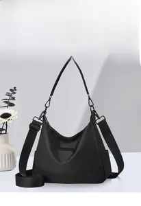 Detail einer schwarzen Hobo-Tasche aus wasserdichtem Nylon mit breitem Gurt