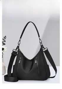 Detail der schwarzen Hobo-Tasche mit Reißverschlusstaschen und abnehmbarem Schultergurt