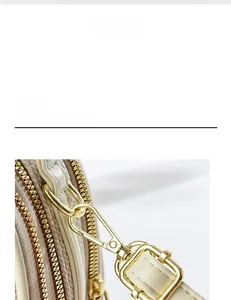 Close-up of golden dual zippers and adjustable metallic hardware on cream leather handbag