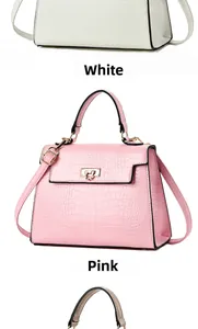 Close-up of crocodile pattern handbags with gold twist locks in white and pink