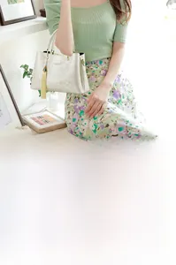 Sac à main blanc avec gaufrage floral et détail de gland jaune dans un cadre élégant