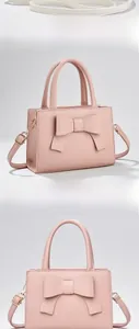 Gros plan du sac à main rose à nœud avec texture litchi et bandoulière dorée