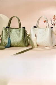 Détail de sacs à main à fleurs gaufrées en vert et beige avec glands en perles