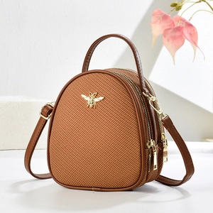 Brown mini crossbody handbag with golden bee accent and textured weave detail