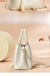 Détails du sac à main beige en jacquard avec motifs floraux et ferrures dorées