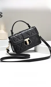 Détail du sac matelassé noir avec fermoir rotatif doré et texture en cuir gaufré