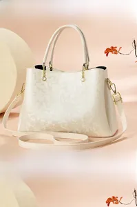 Détails du sac à main crème avec gaufrage floral et perles sur le côté et à l'arrière