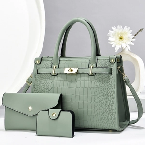 Detailed view of mint green crocodile pattern handbag set with golden hardware and floral decor