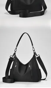Detailansicht der schwarzen Nylon-Schultertasche mit Reißverschlüssen und breitem Gurt
