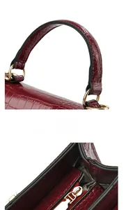 Detail of burgundy crocodile-embossed handbag with comfortable handle and gold hardware