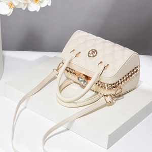 Détail du sac matelassé crème avec fermoir diamant et doubles chaînes dorées