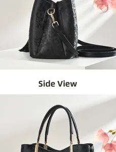 Detail of black embossed floral handbag featuring gold hardware and decorative tassel