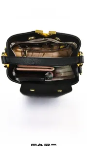 Vue intérieure du sac à main en cuir noir avec boucle dorée et compartiments spacieux