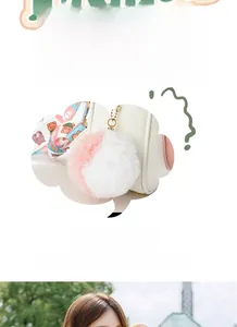 Detail of light cream crossbody bag with pink plush pompom and cartoon pig shoulder strap