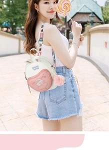 Detail view of pink rabbit ears on white girl backpack with cute embroidery and fur ball