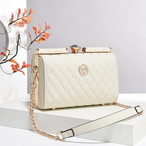 Détail du sac bandoulière matelassé beige avec ferrures dorées et fermoir bijou rotatif