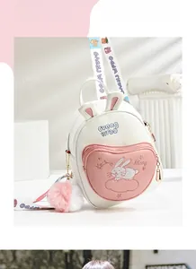 Detail of cute ivory backpack with rabbit ears, heart pocket, and plush pendant