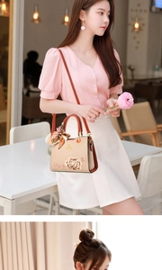 Detailed close-up of elegant beige floral embroidery on the luxury top-handle handbag