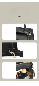 Detail der schwarzen Kieselleder-Handtasche mit verstärktem Griff und goldenen Beschlägen