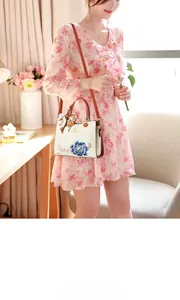Detail of elegant embroidered blue peony pattern on premium cream-white handbag with scarf