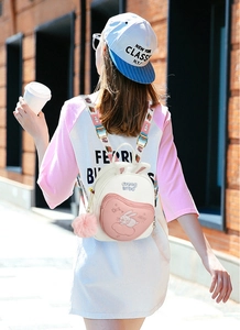 Detail view of rabbit ears and cartoon embroidery on a soft pink and white backpack