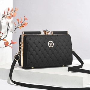 Sac bandoulière matelassé noir élégant avec cadre doré et fermoir cristal sur socle
