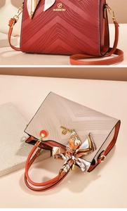 Detail view of embossed leather handbags with silk scarf handle and metal charms