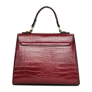 Elegant deep red crocodile pattern handbag with trapezoid shape and gold metal accents