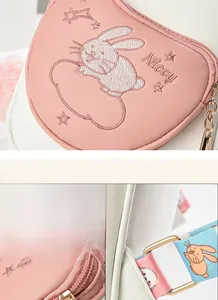 Close-up of rabbit embroidery and durable golden metal zippers on a cute backpack