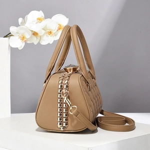 Chic sac à main beige matelassé avec grand fermoir diamant sur un support élégant