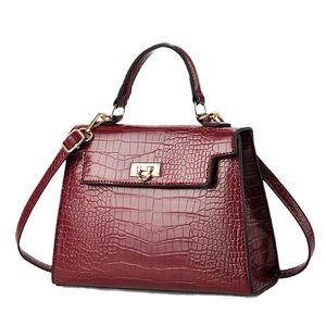 Dark red crocodile pattern handbag with gold hardware and trapezoidal shape